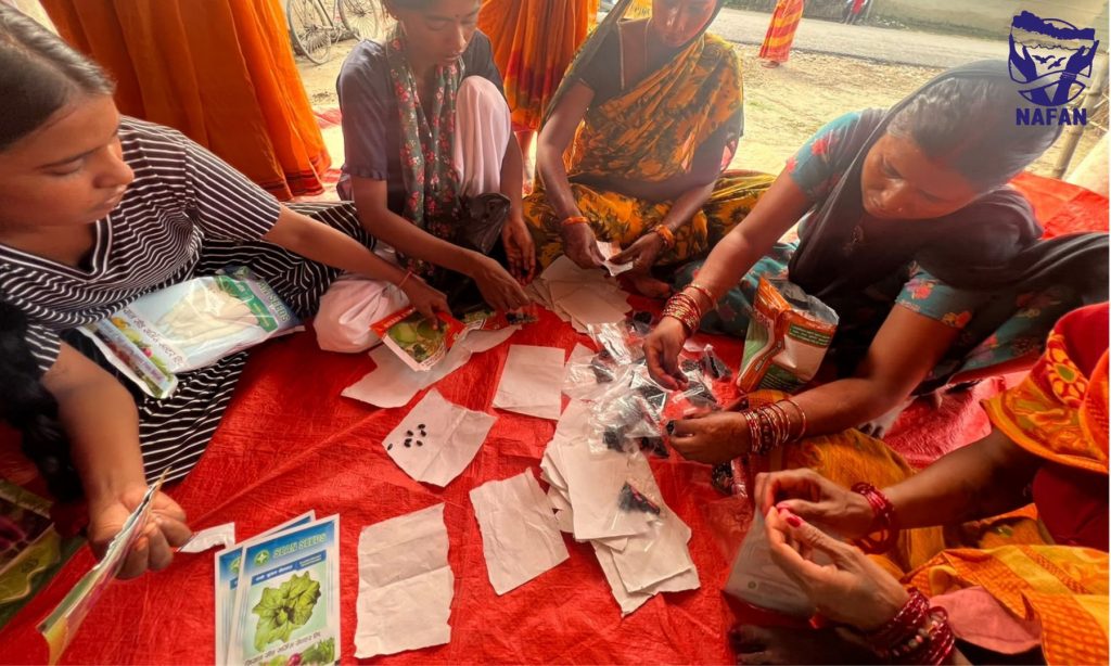 Women kneeling on a red mat sorting seed into paper packets