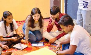 Young participants sitting on a patterned carpet working through a group task